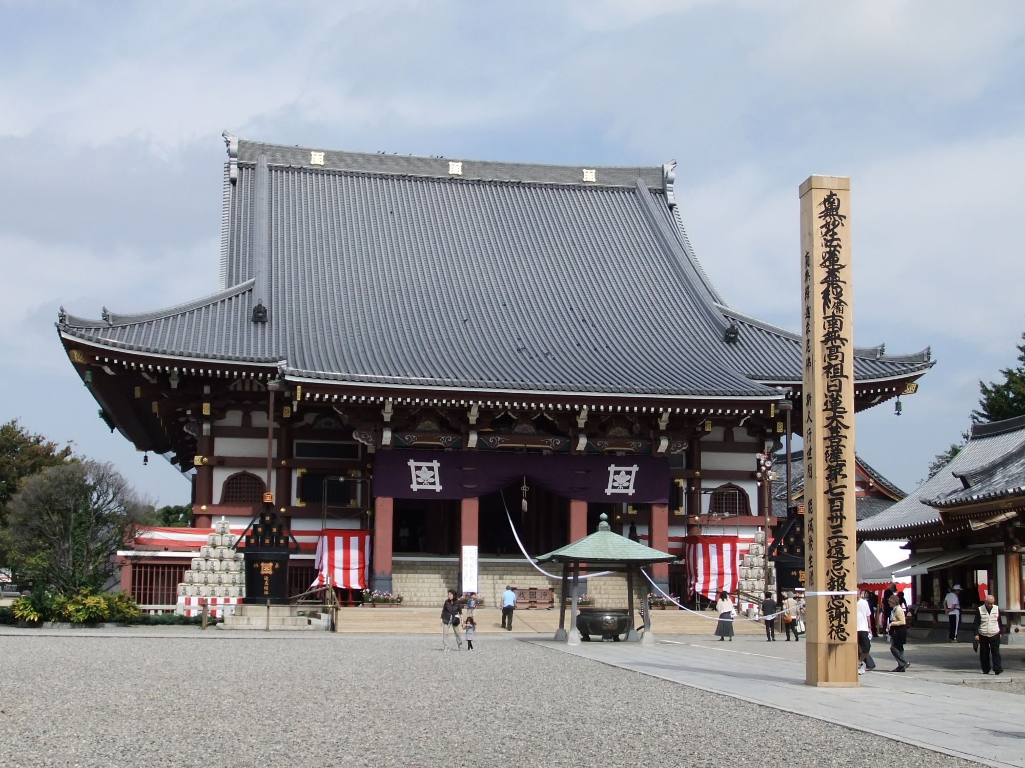 A traditional Japanese building with a curved roof and wooden pillars.