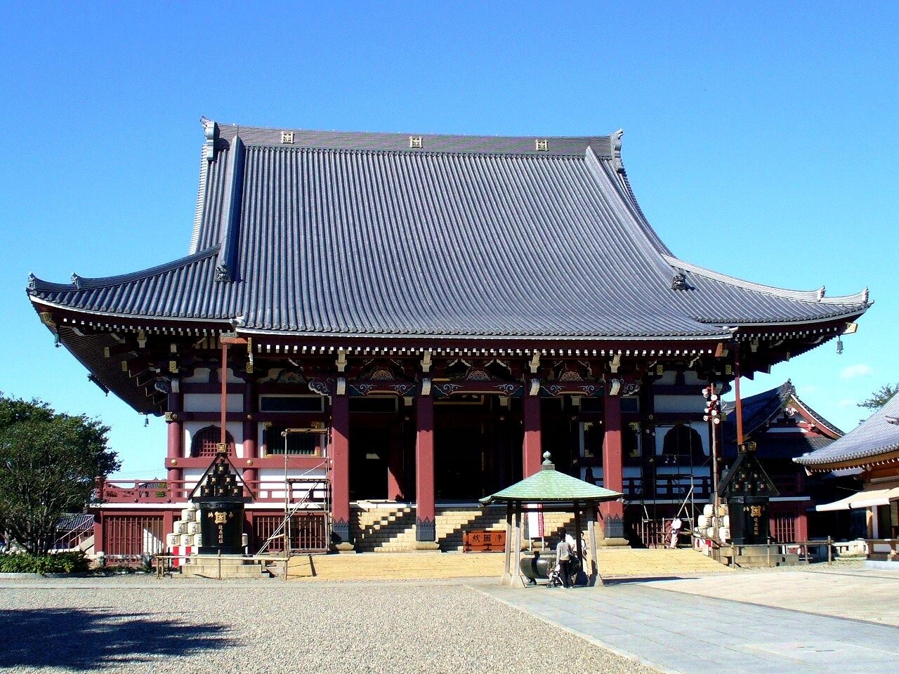 A traditional Japanese temple with a curved roof and red columns.