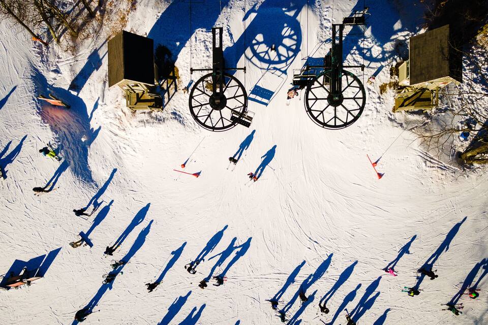 A ski lift with skiers descending.