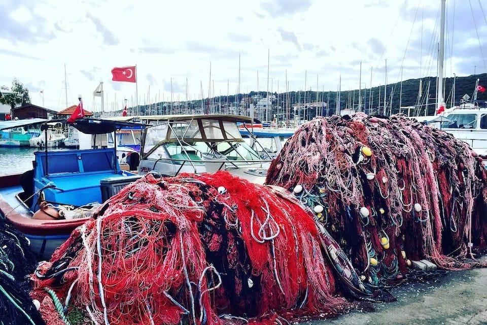 Een jachthaven met boten en vissersnetten.