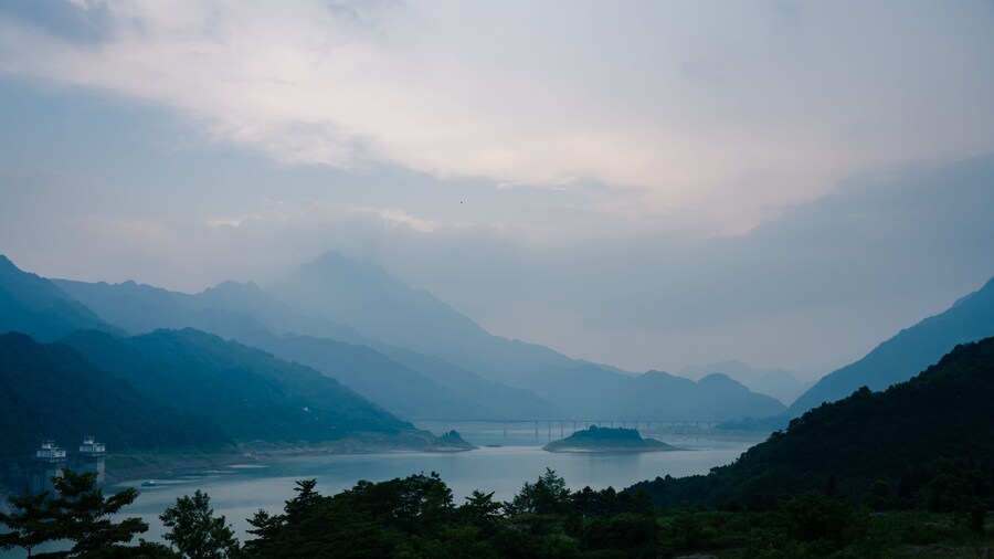 Zengwen Dam against the silhouettes of the green mountains on a foggy day