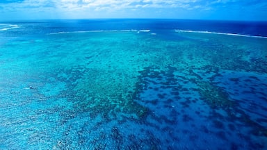 A turquoise sea with coral reefs and a small boat.