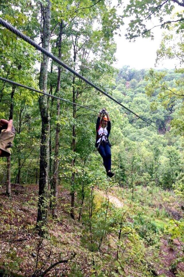 A person zip-lining through a forest.