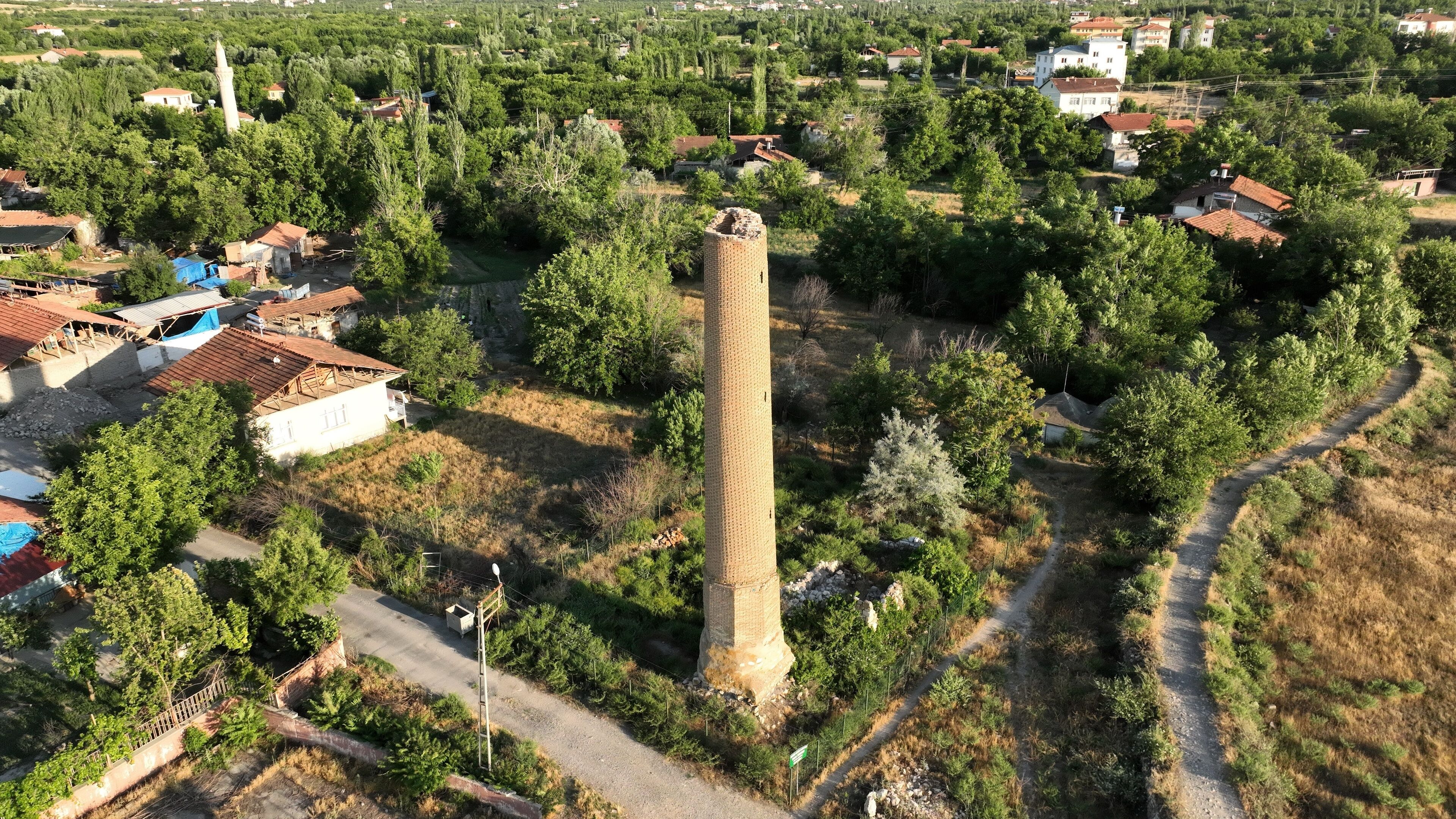 A tower surrounded by trees and houses.