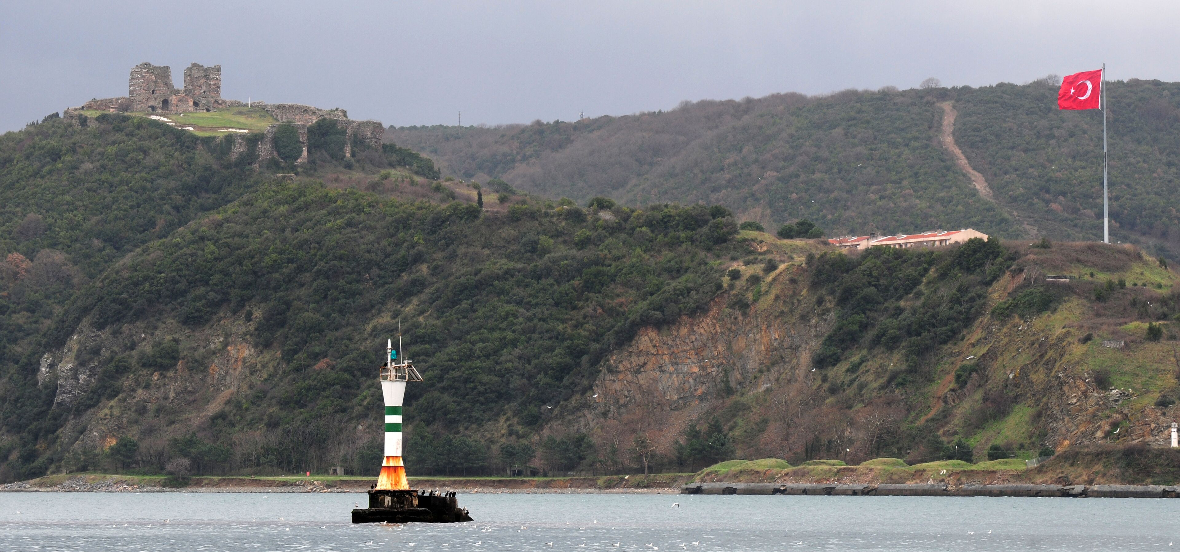 A lighthouse on a buoy, a castle on a hill, and a flag on a pole.
