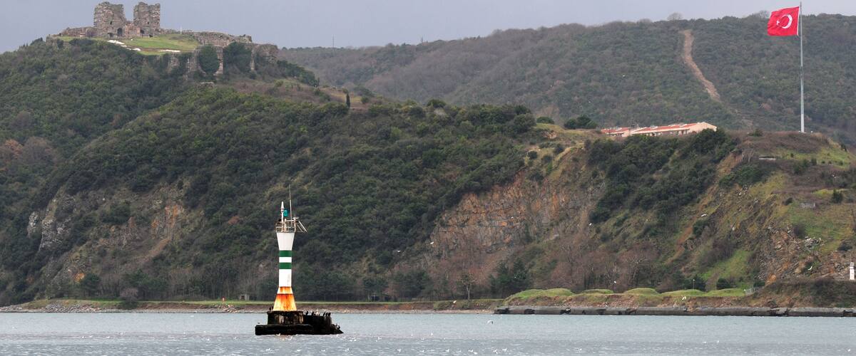 A lighthouse on a buoy, a castle on a hill, and a flag on a pole.