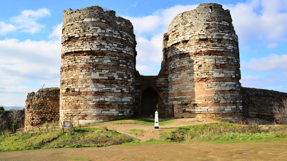 A historic stone castle with two large towers and a central archway.