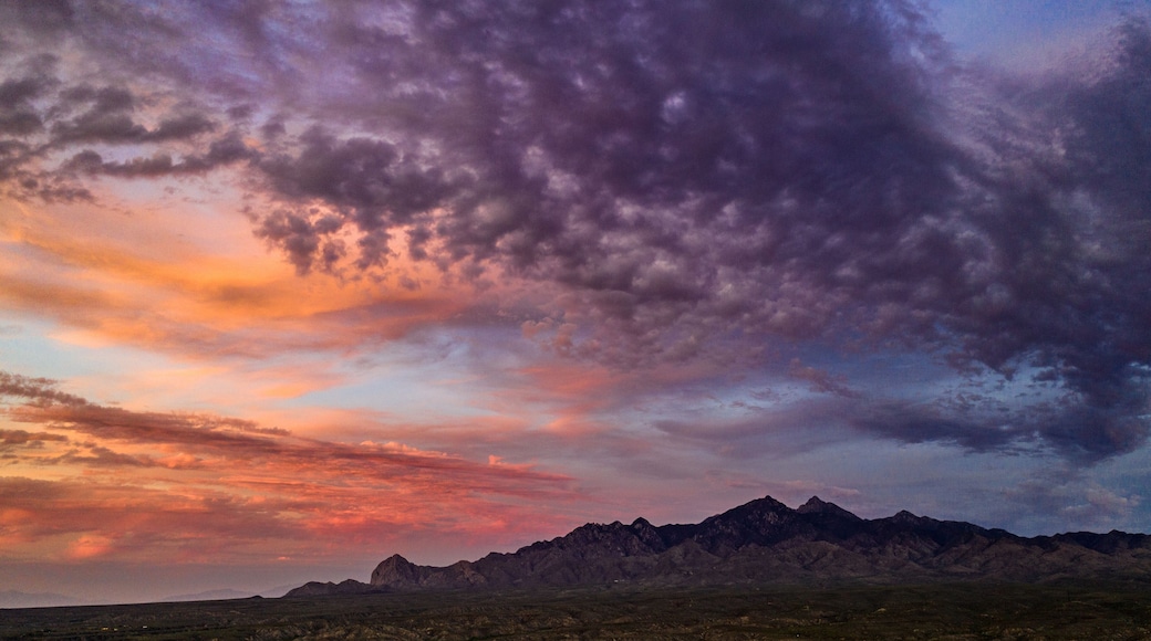 Sunset, aerial landscapes of Santa Rita Mountains from above Tubac, Arizona with warm , golden plains, purple mountains, blue sky with colorful clouds on a Fall day