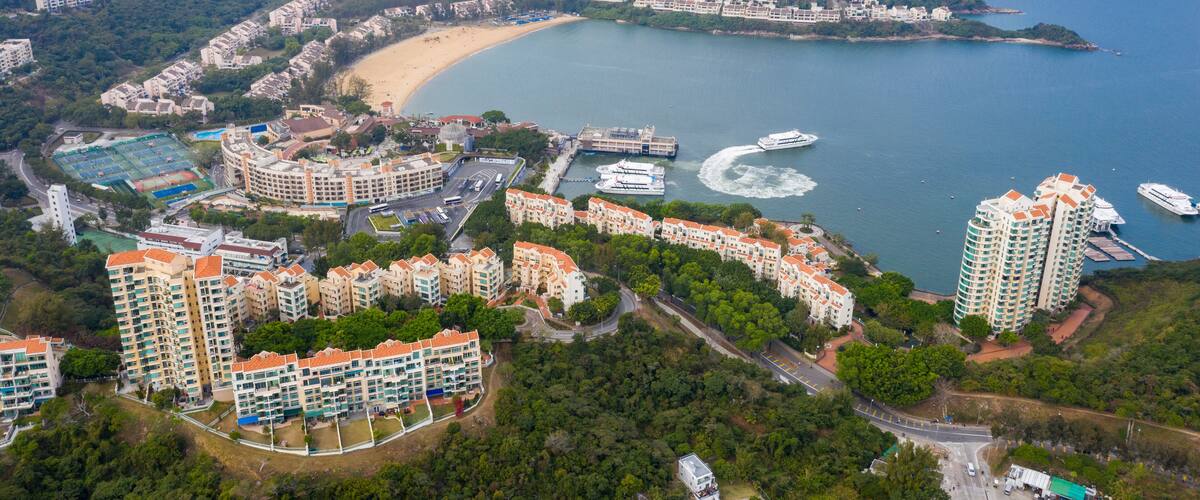 A coastal residential area with high-rise buildings, a beach, and a marina.