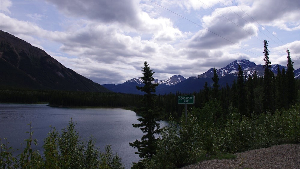 Good Hope Lake surrounded by mountains and dense forest.