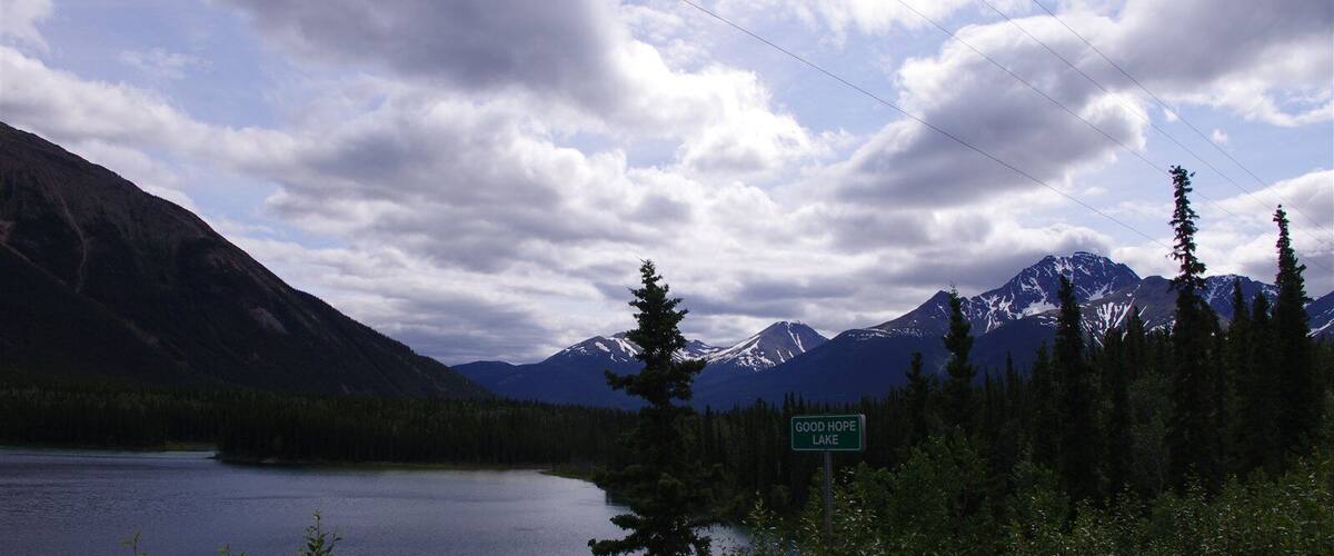 Good Hope Lake surrounded by mountains and dense forest.