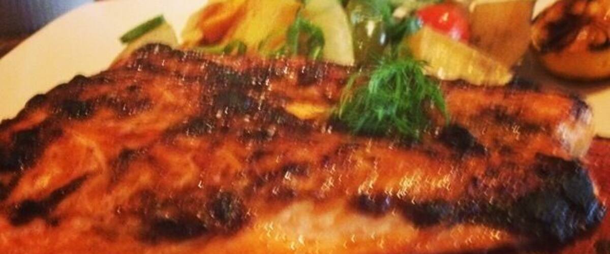 A grilled steak with vegetables on a plate.