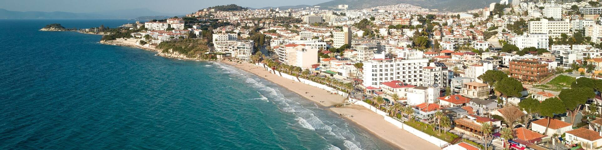 Aerial view of a beach located in Kusadasi with a large pier extending into the ocean