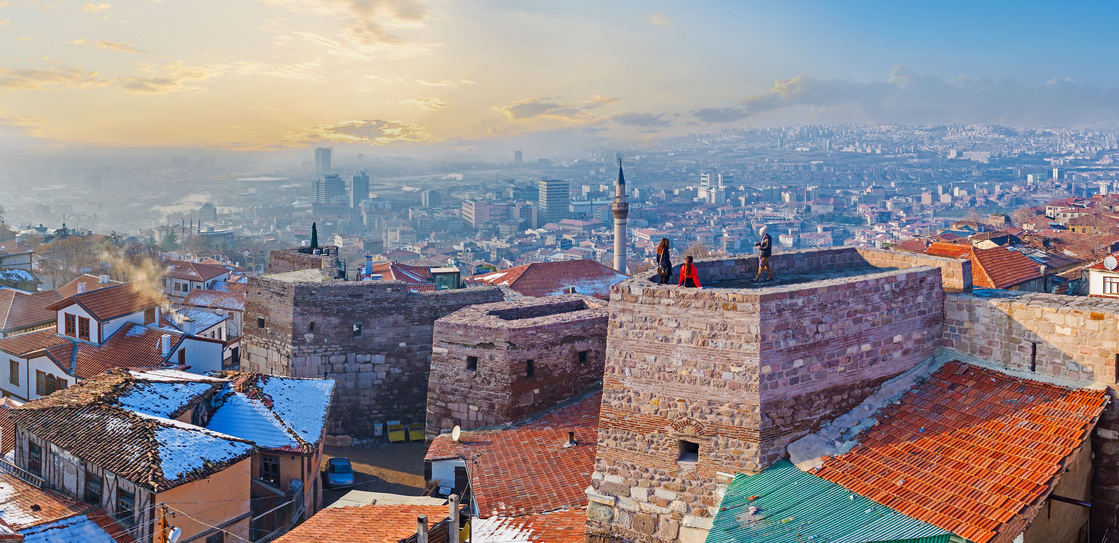 A historic cityscape with stone fortifications and traditional buildings.
