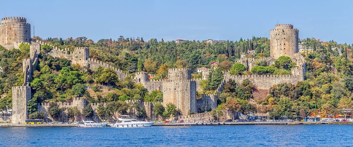 A coastal city with historic stone fortifications and a marina.