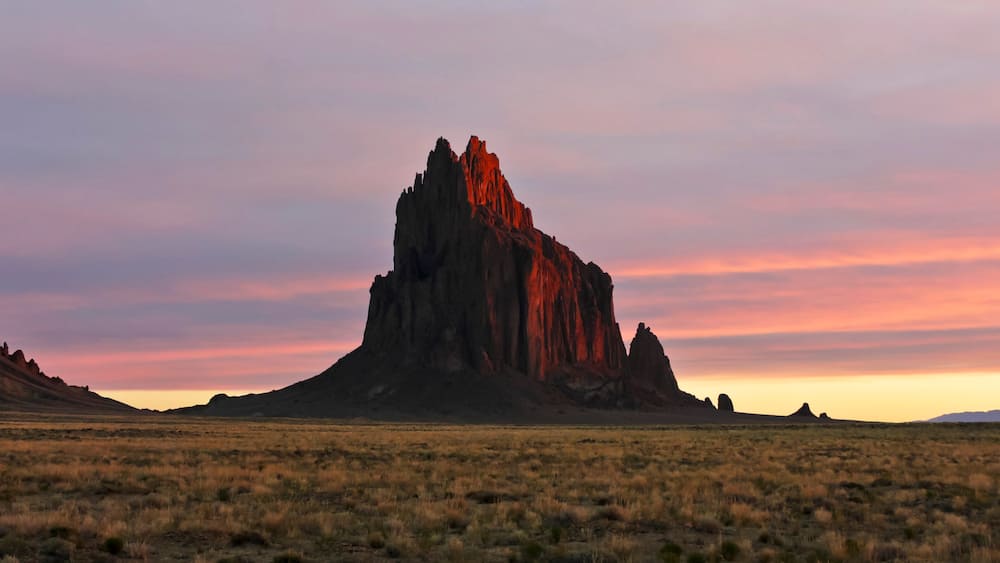 A Shiprock Landscape Against a Striated Sunrise Sky