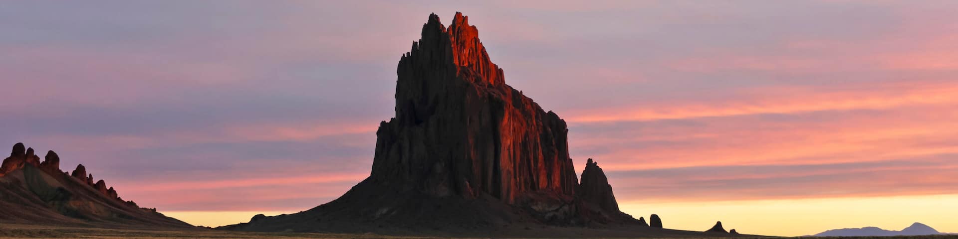 A Shiprock Landscape Against a Striated Sunrise Sky