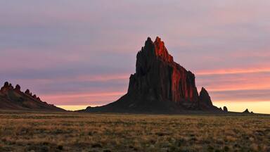 A Shiprock Landscape Against a Striated Sunrise Sky