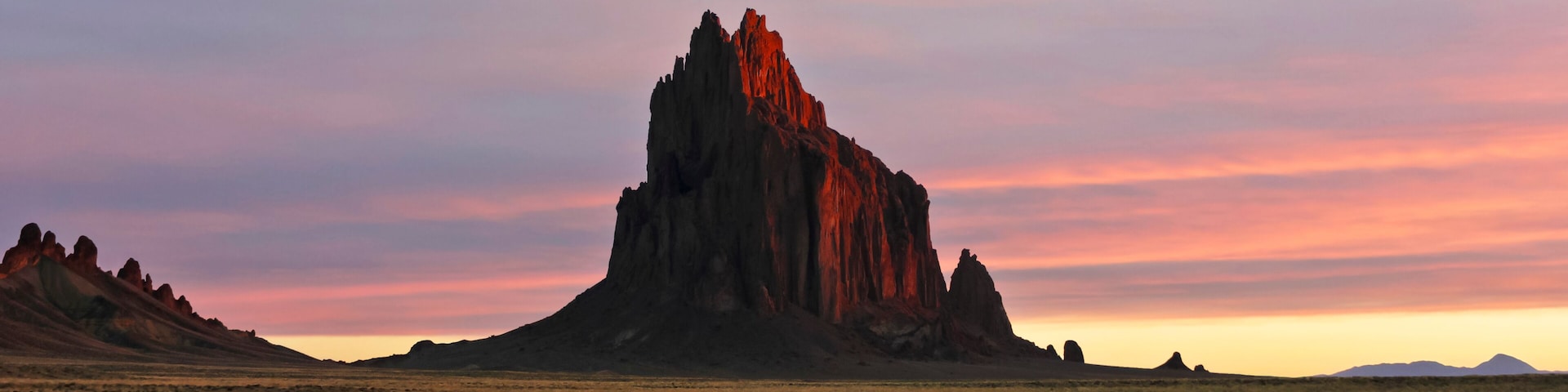 A Shiprock Landscape Against a Striated Sunrise Sky