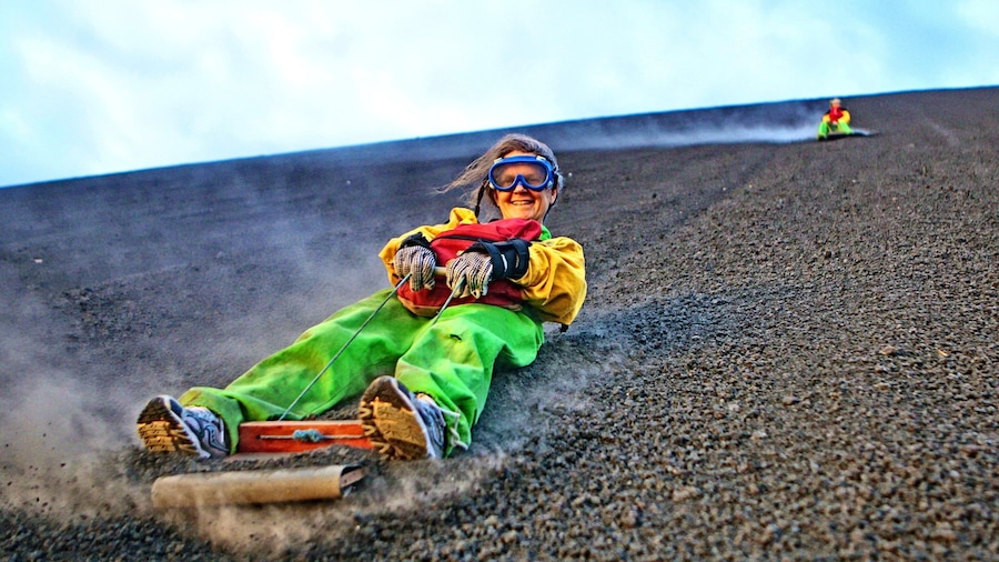 A person sledding down a steep, rocky slope.
