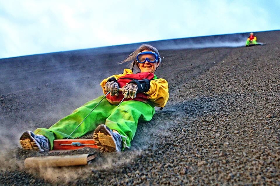 A person sledding down a steep, rocky slope.