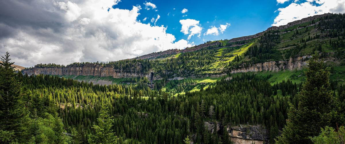 A mountainous landscape with dense forests and a valley.