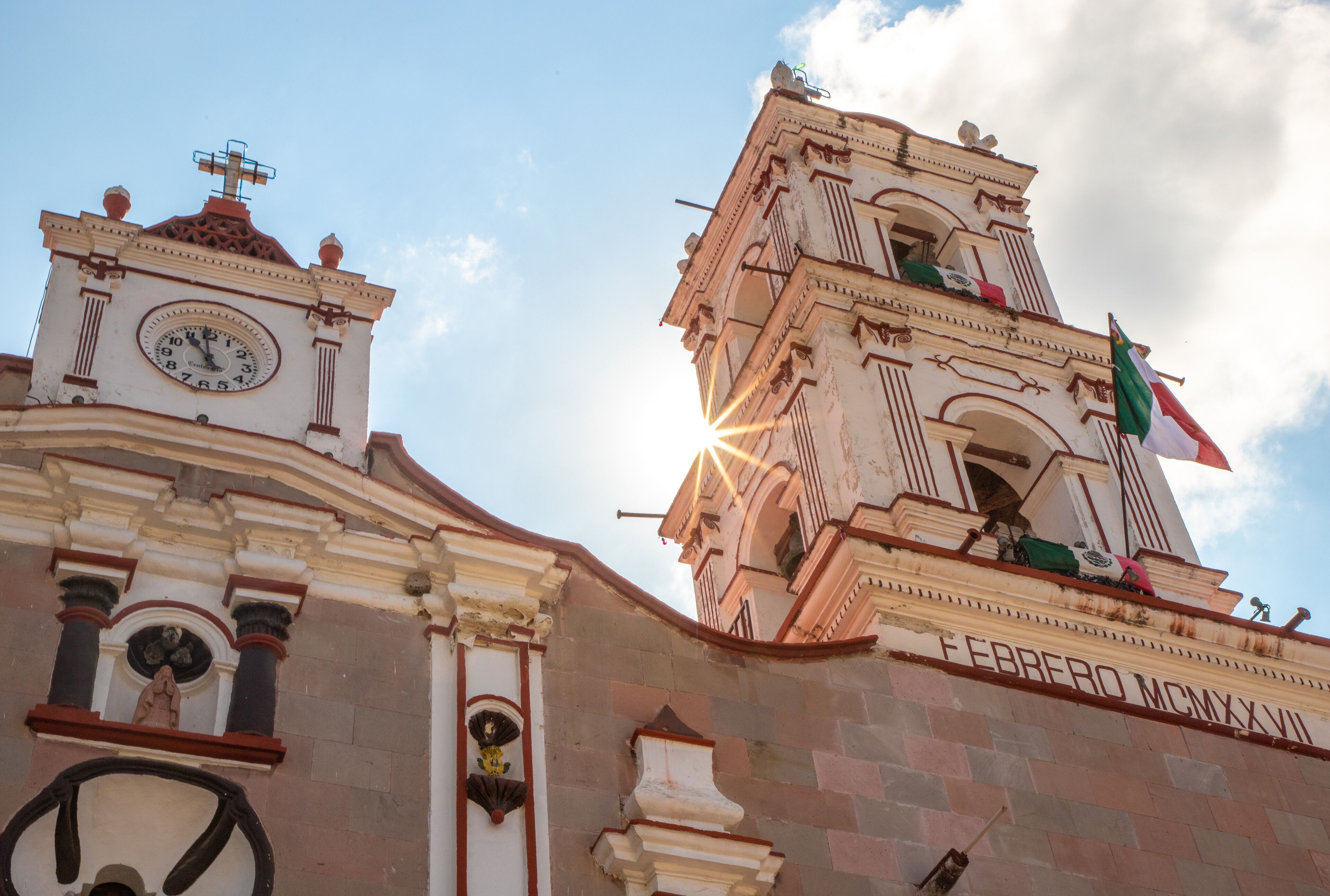 A historic building with a clock tower and a weather vane.