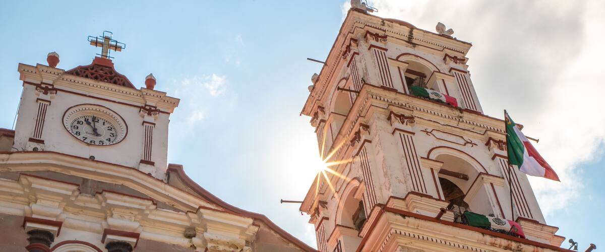 A historic building with a clock tower and a weather vane.