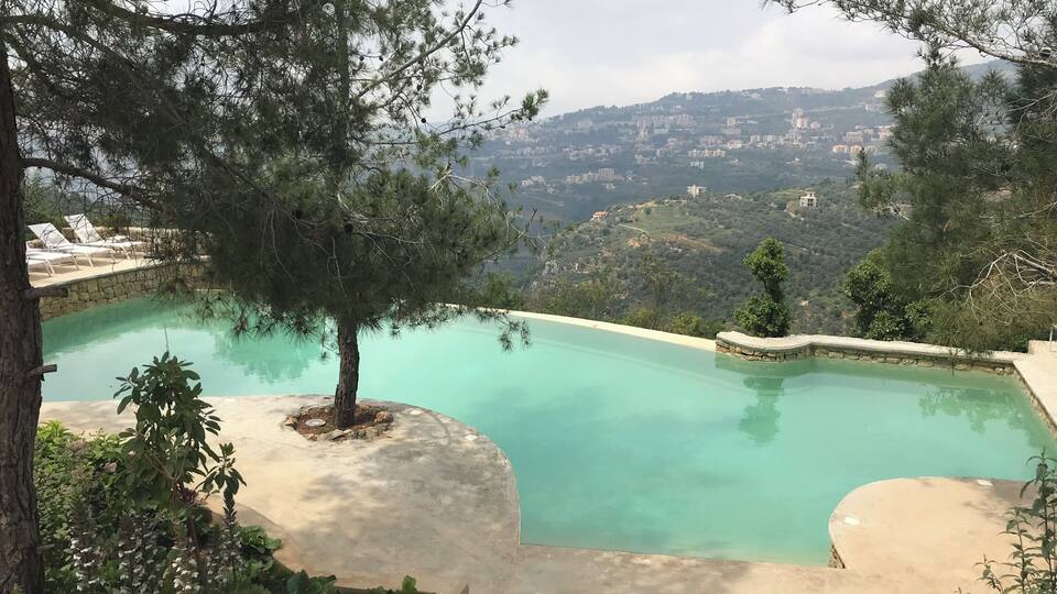A swimming pool with a view of a hillside town.