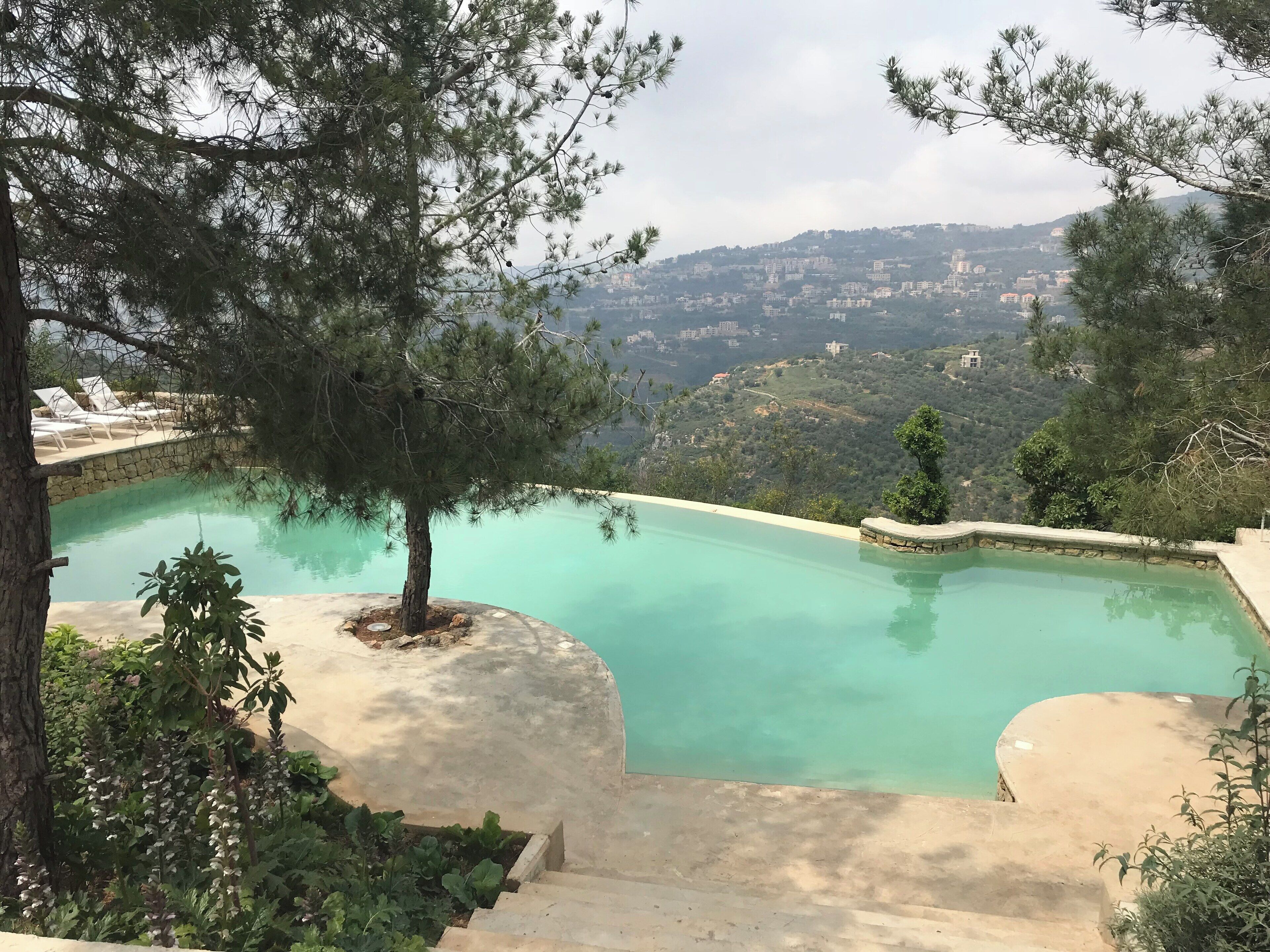 A swimming pool with a view of a hillside town.