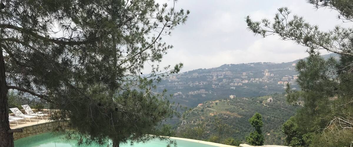 A swimming pool with a view of a hillside town.