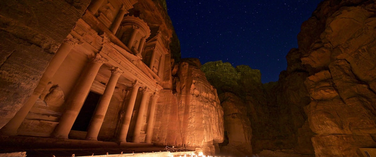 Wadi Musa which includes heritage architecture, night scenes and a gorge or canyon