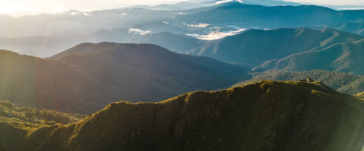 A mountainous landscape with layered peaks and valleys.