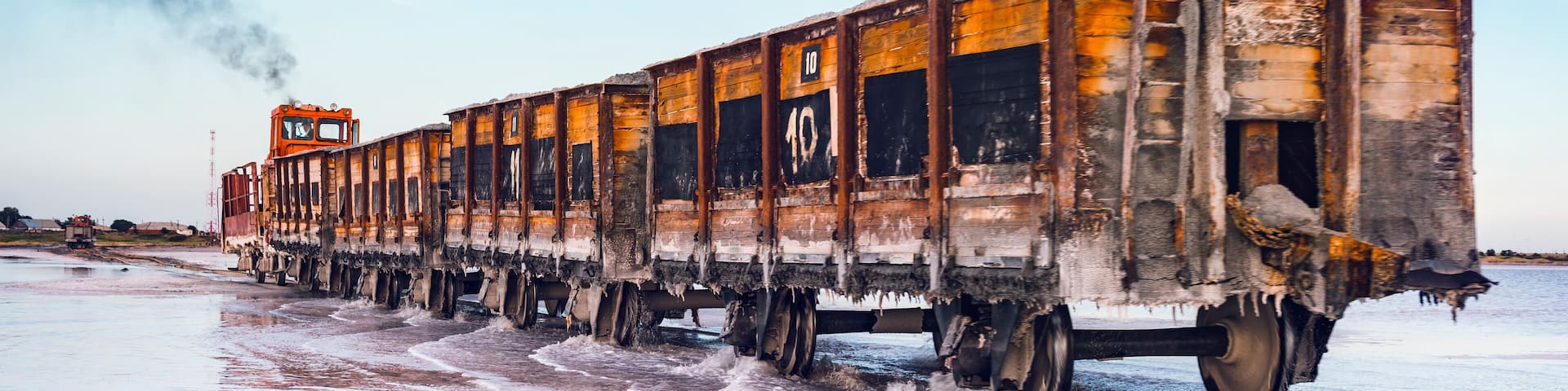 Awesome train rides on rail in the water with white salt on the background of beautiful blue sky.
