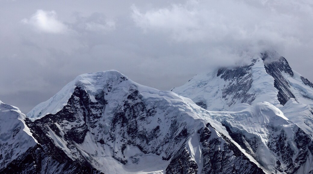 Minya Konka (Mount Gongga, Holy Tibetan Snow Mountain) - Gongga Shan in Sichuan Province, China. View from the west at Yaha Pass, summit shrouded in clouds. Highest Mountain in Sichuan Province China.