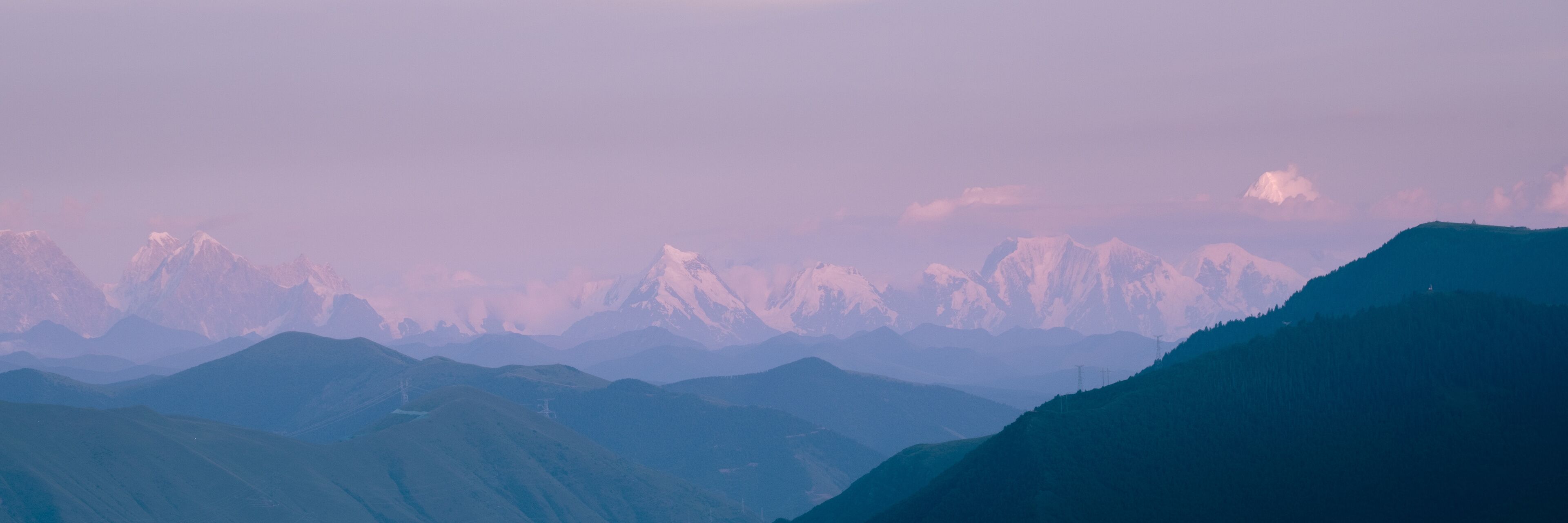 A mountain range with snow-capped peaks and a clear sky.