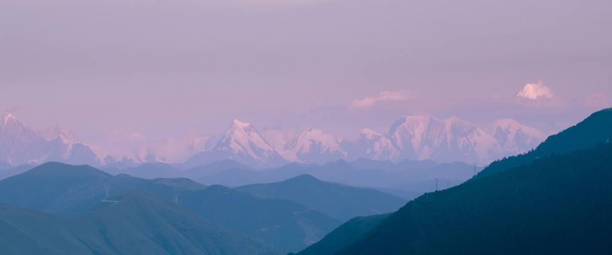 A mountain range with snow-capped peaks and a clear sky.