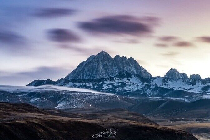 Cordillera nevada con cielo nublado.