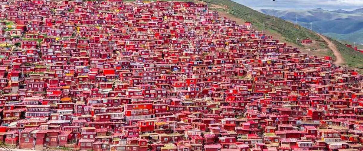 A densely packed hillside settlement with numerous red buildings.