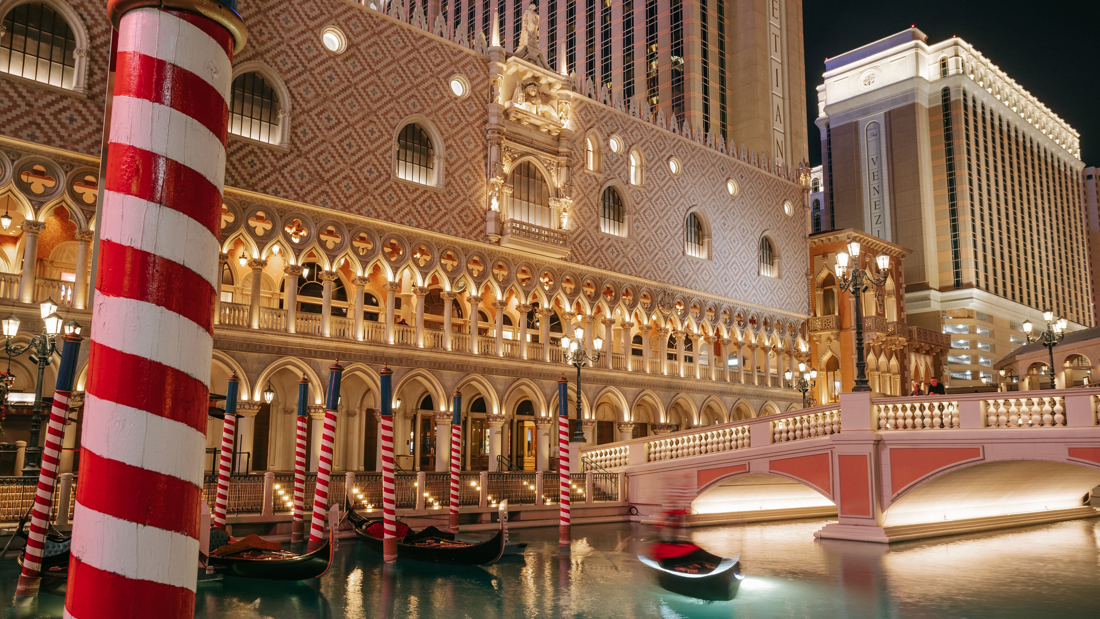 The Venetian Casino which includes night scenes, a river or creek and a bridge