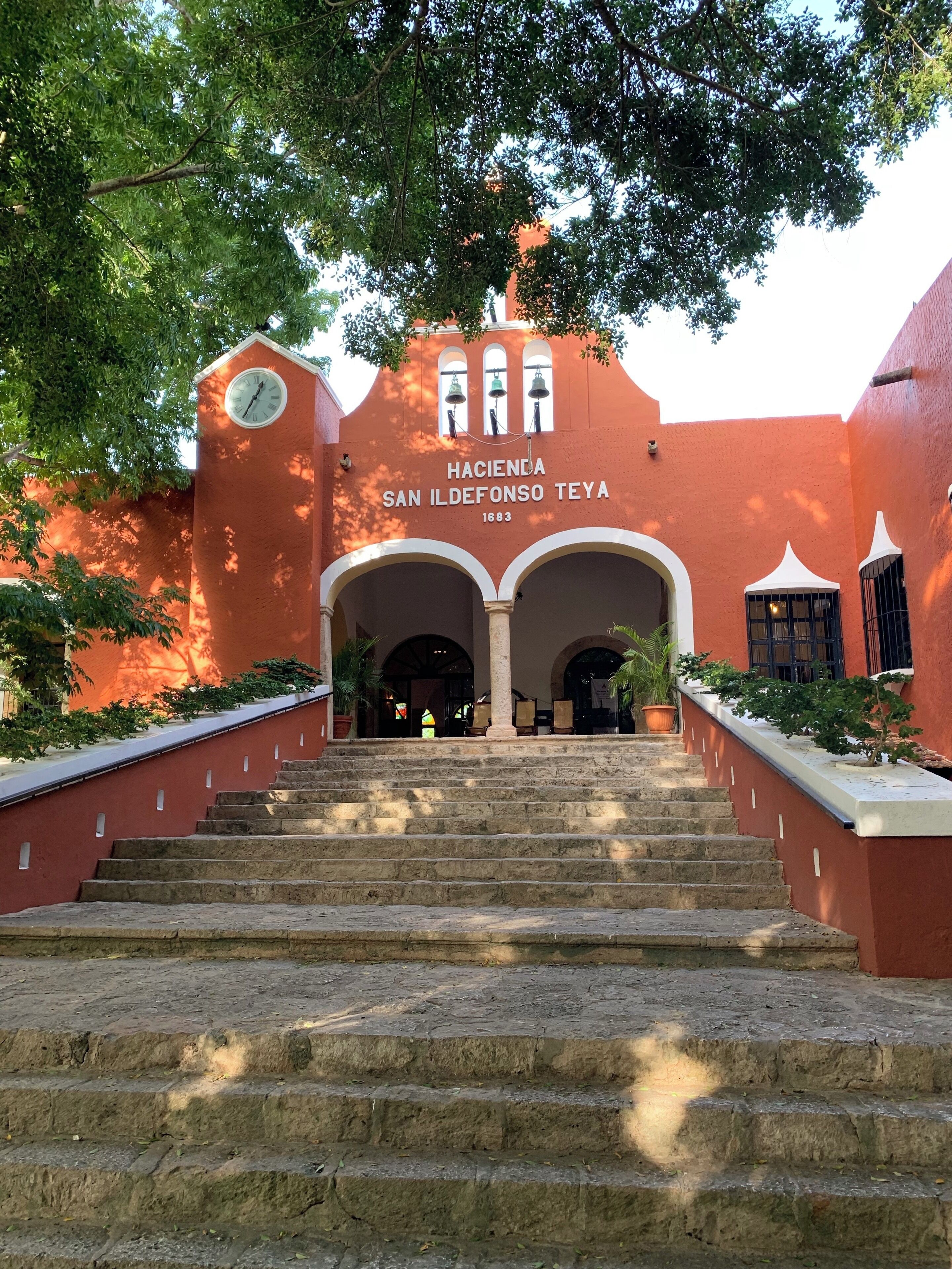 A staircase leading to a building with a clock and the text "Hacienda San Ildefonso Teja 1683".