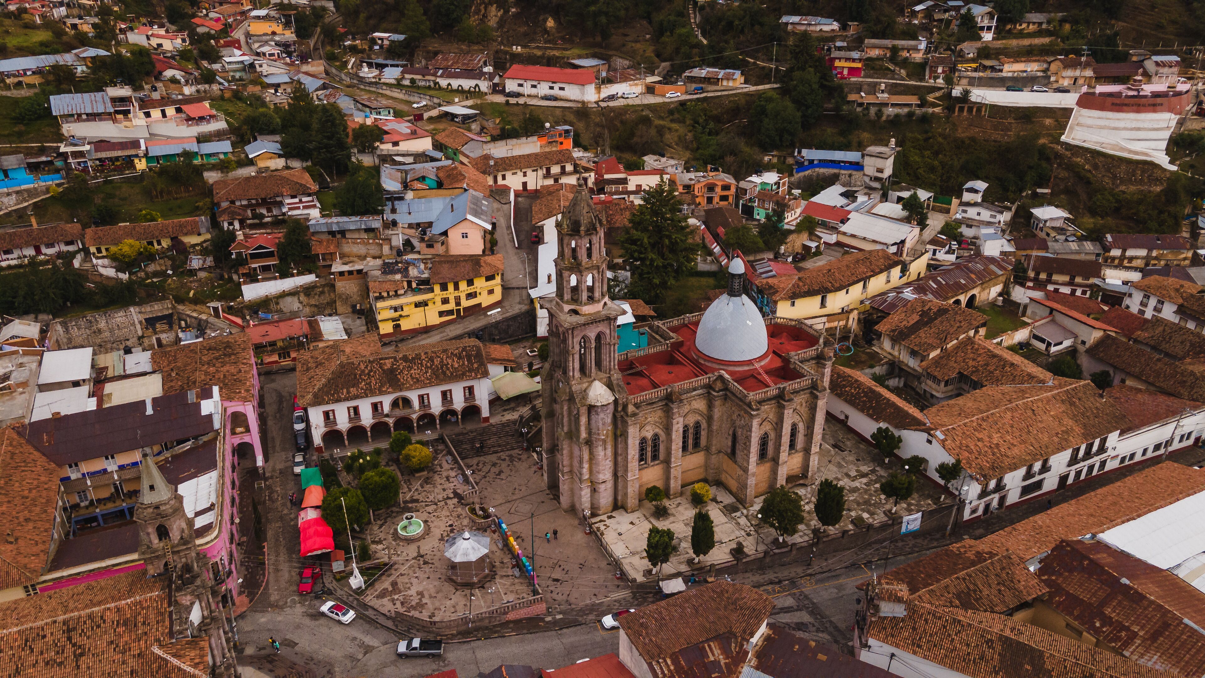 An aerial view of a historic town with a prominent church, narrow streets, and colorful buildings.