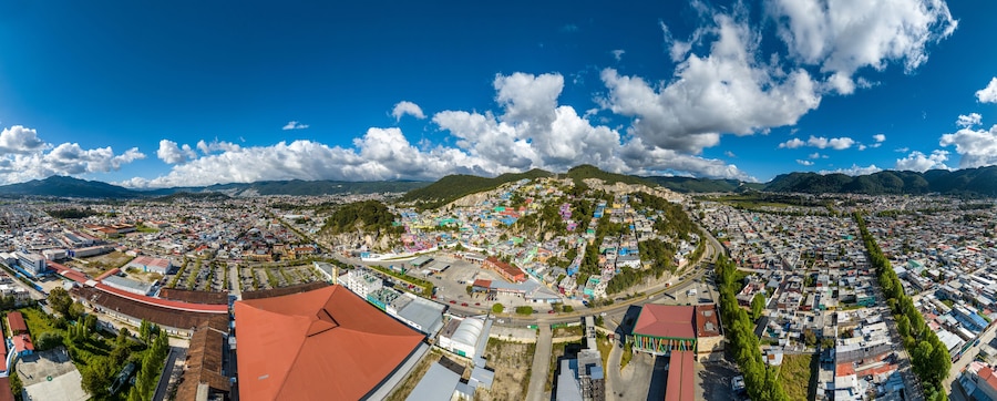 Aerial view of colorful mountain village of San Cristobal de Las Casas in Mexico. Clouds over the mountains. Panorama.