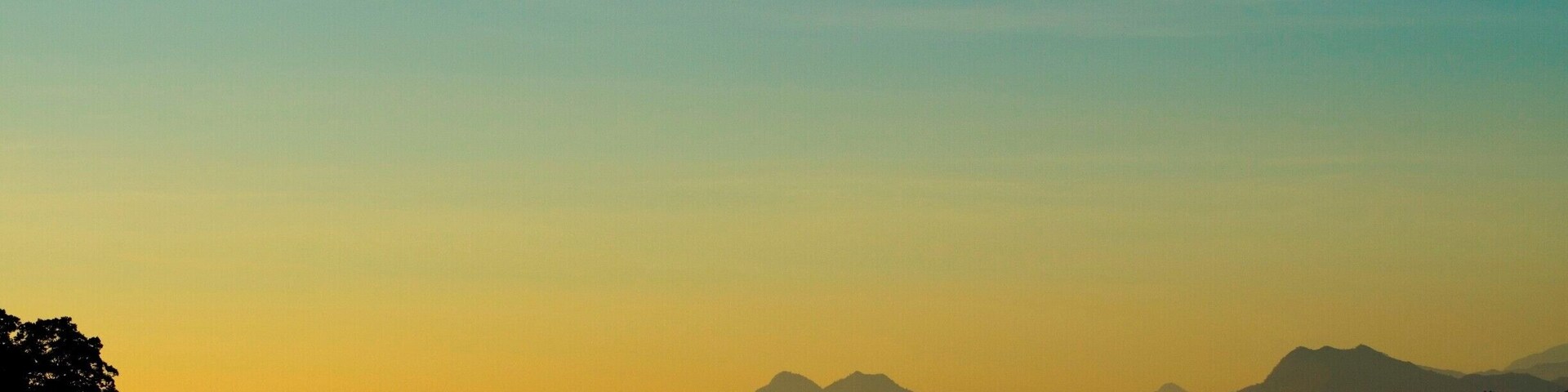 Silueta de una cordillera contra un cielo degradado.