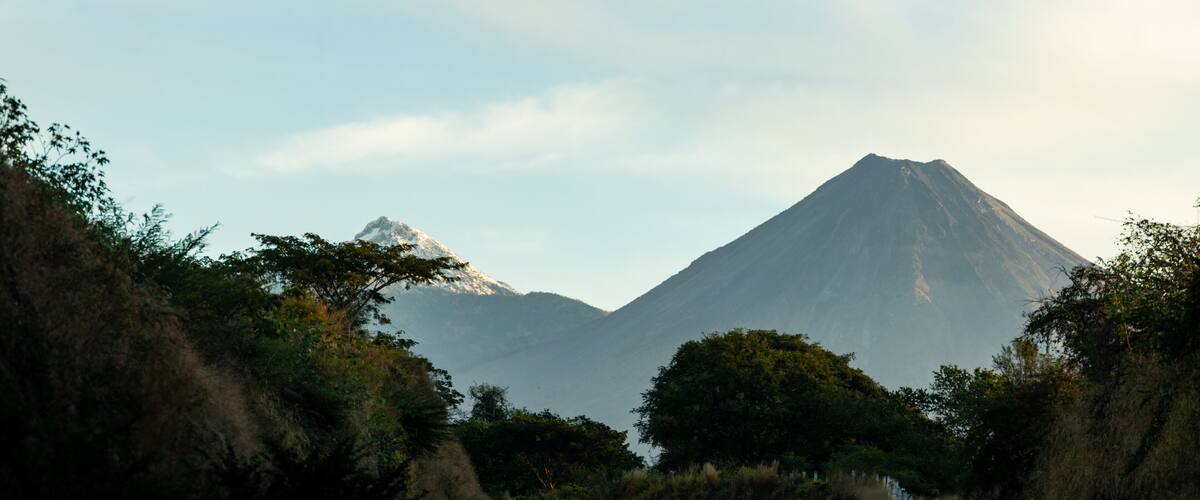 A mountain range with a prominent peak and surrounding vegetation.