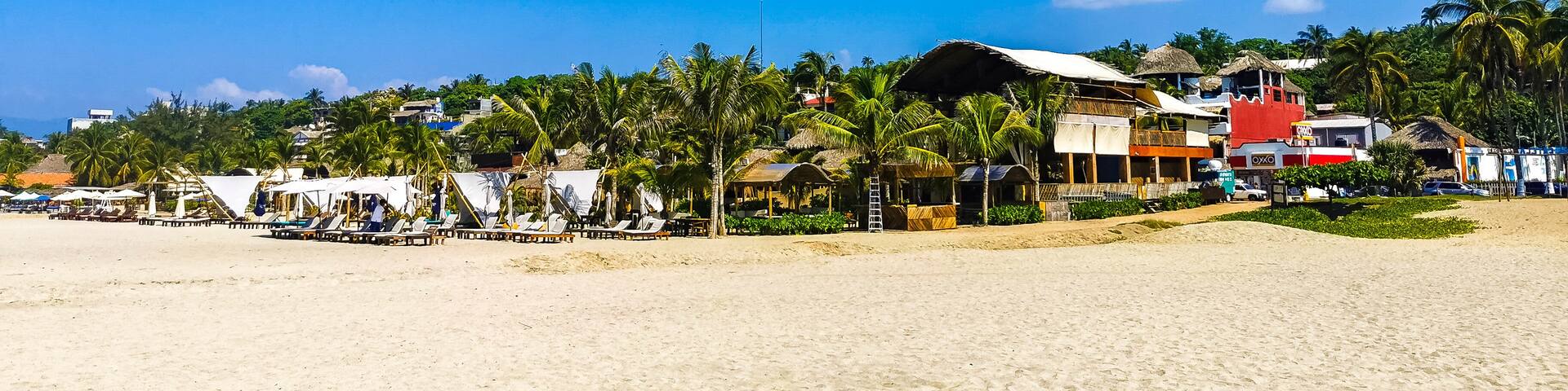 Sun beach people waves and boats in Puerto Escondido Mexico.