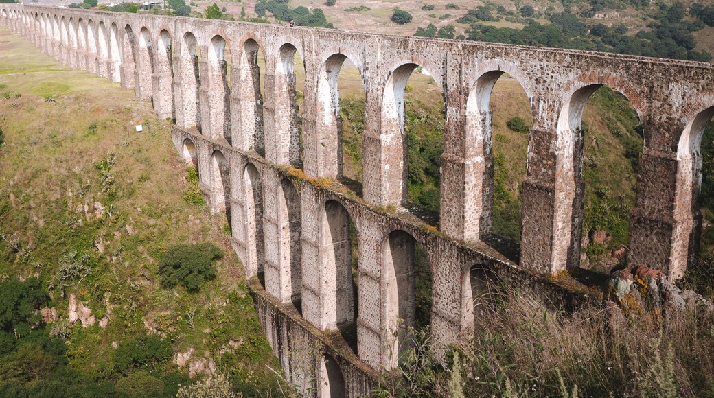 Een lange viaduct met meerdere bogen die een vallei overspant.
