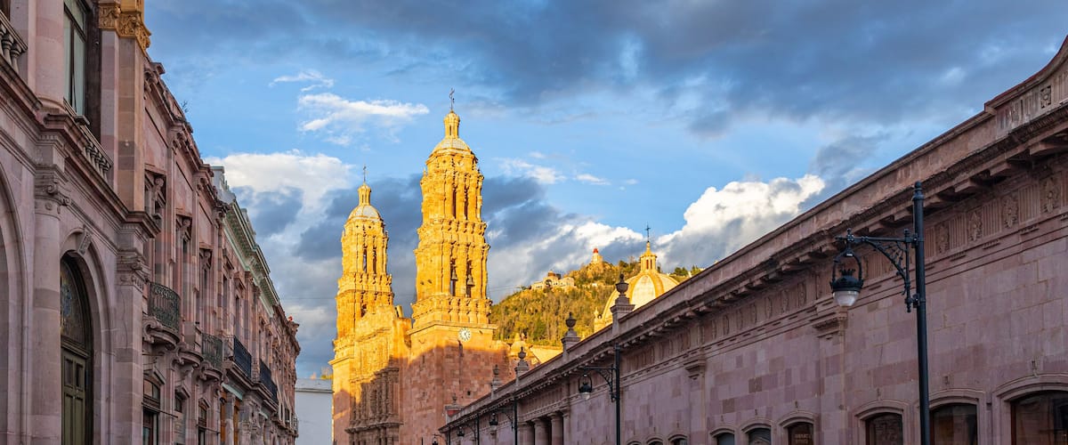 A historic building with two prominent towers and a clock tower.