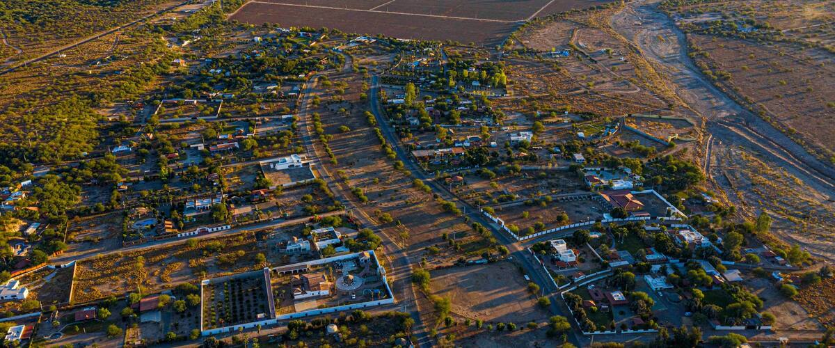 An aerial view of a town with a mix of residential and agricultural areas, roads, and scattered buildings.