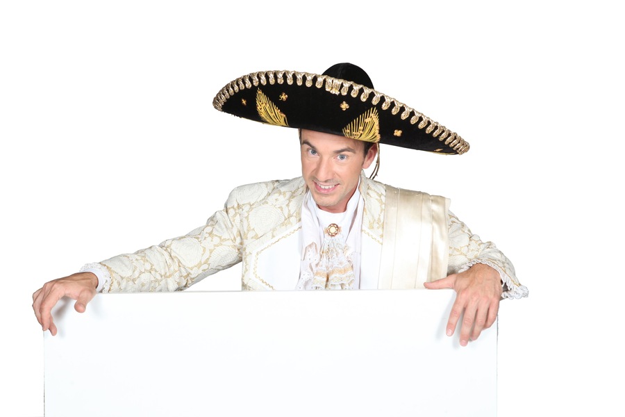 Man in a mariachi costume with board for message